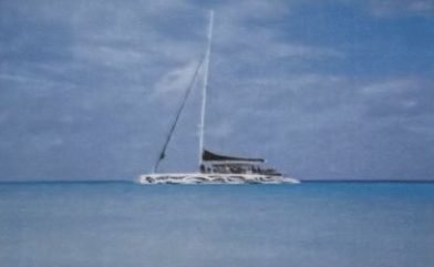 A catamaran on the water at sunset, with the sky turning orange.
